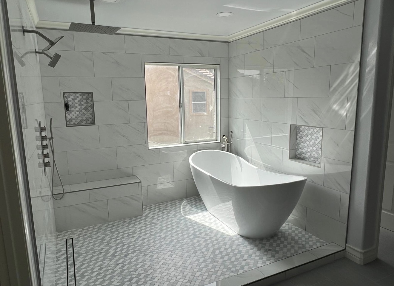 Freestanding soaking tub with rain shower and fish scale niches